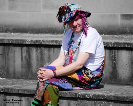 Colourfully dressed man sitting outside Leeds Central Library
